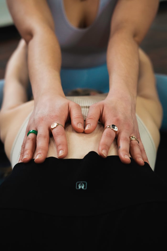 Yoga teacher assisting a student in a New York studio for enhanced well-being and relaxation.